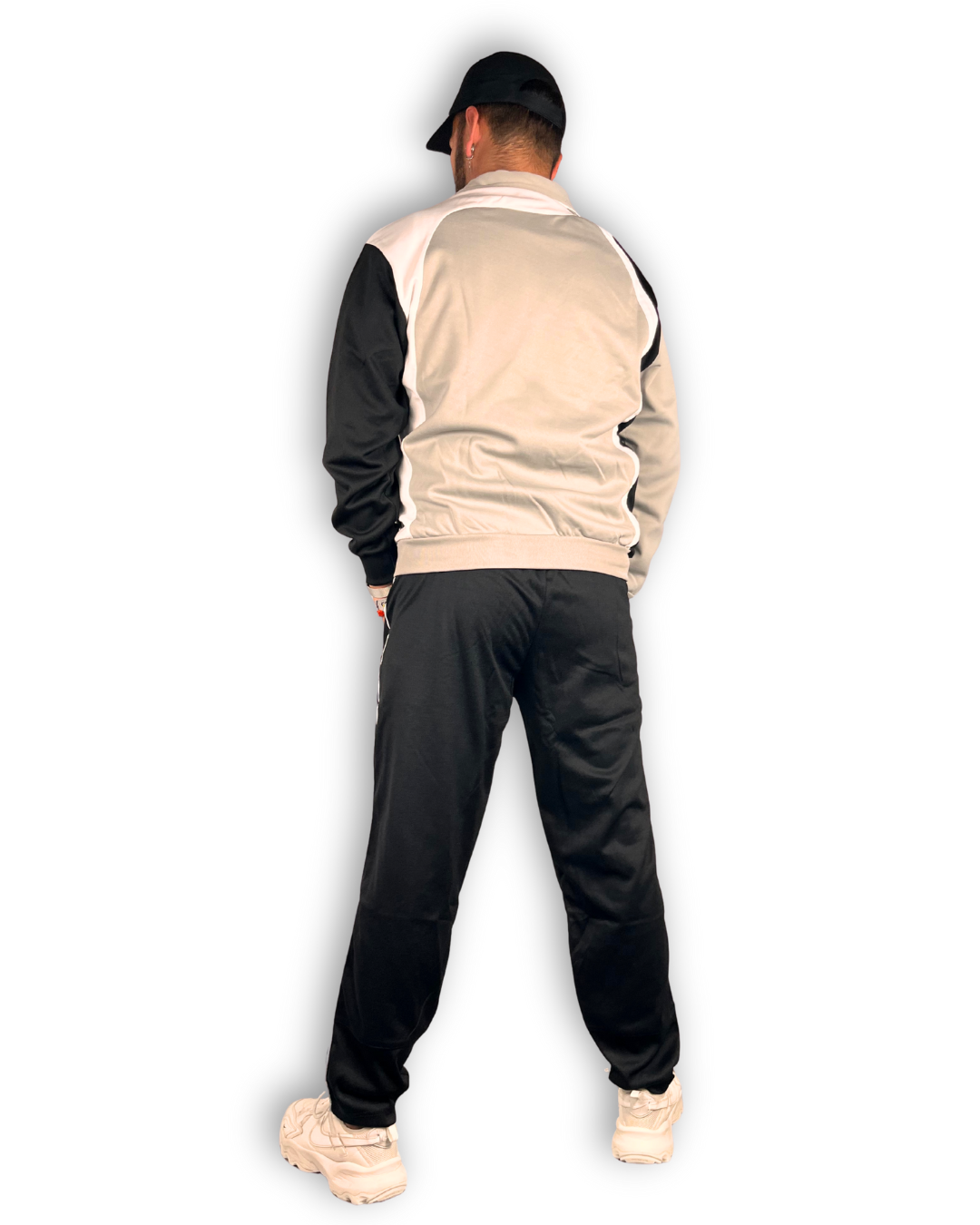 anzug freizeit und sport günstig marke dragon sport grau weiß und schwarz mit schwarzer hose männliches model mit cap und weißen sportschuhen