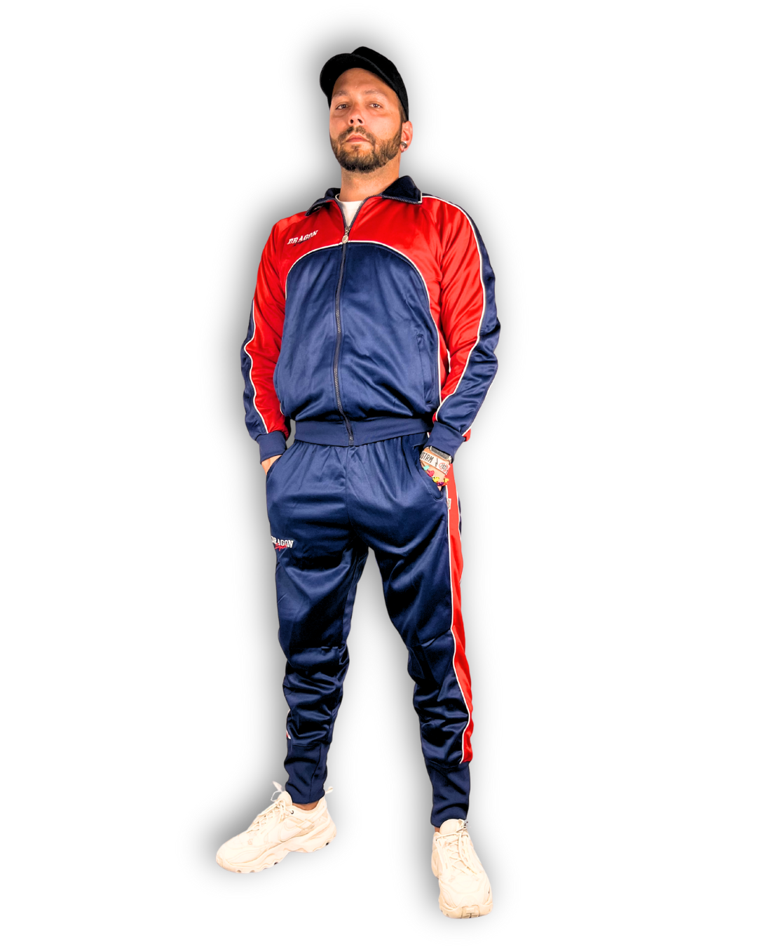 model männlich mit trainingsanzug rot blau marke dragon sport. trägt cap schaut in kamera. weiße schuhe an. 
